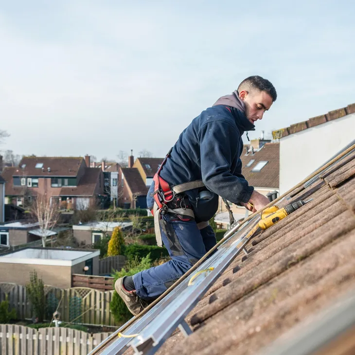 Worker fixing rooftop solar panels